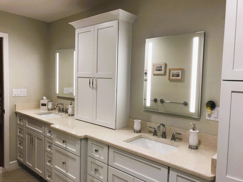 Custom master bathroom remodel with double vanity, white cabinetry, and lighted mirrors in Wallingford, CT.